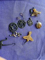 Overview of all earrings on purple fabric