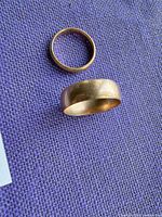 Both yellow gold rings on purple fabric