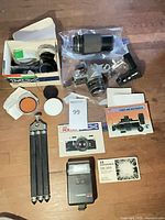 Overview of all items: Pentax MX camera with lens, zoom lens in bag, flash, tripod, filters, manuals, accessories