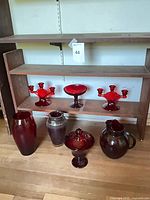 All seven ruby glass items on shelving