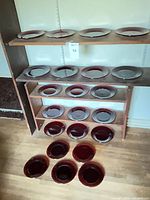 Shelving unit with multiple red glass plates displayed, showing quantity and color