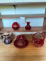 Group shot of all five ruby red glass pieces on shelf