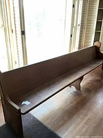 Full length view of the wooden church pew from front angle