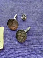 Front view of round cufflinks with monogram and square tie tack