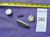Overview of four brooches with tape measure for scale