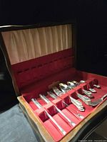 Open wooden chest showing entire flatware set