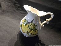 Three-quarter view of pitcher showing lemon design and scalloped rim
