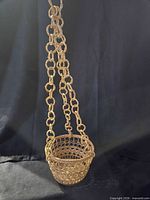 Full view of hanging wicker basket showing chain and bowl