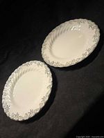 Two identical Johnson Brothers Snowwhite Regency plates side by side on dark background