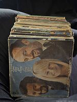 Front view of stacked vinyl LPs showing top album with male and female portrait cover