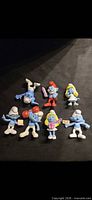 All eight McDonald’s Smurfs figurines arranged on dark background
