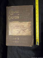 Front cover of 1900 Galveston Horror book with tape measure for size
