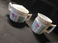Angled view of creamer and sugar bowl showing floral and gold beaded decoration