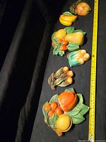 All six fruit plaques lined with tape measure