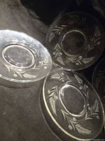 Three clear glass saucers showing etched wheat & berries design