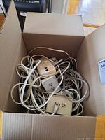 Open box showing tangled cords and wall plates
