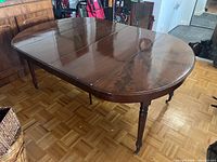 Full view of oval dining table with leaves inserted