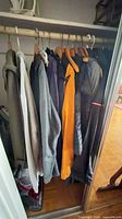 Multiple jackets, vest and robes on closet rod
