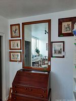 Full view of mirror mounted above desk showing scale and frame design