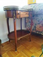 Full view of side table showing marble top, drawer, shelf, legs