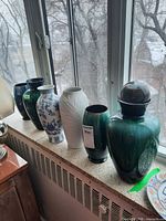 Six vases lined on windowsill showing size range and finishes