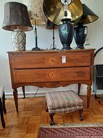Front view of dresser with two drawers, tapered legs, other items on top not included