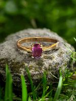 Front view of ring displaying oval garnet stone and prong setting