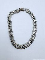 Full view of sterling silver anchor link bracelet laid flat