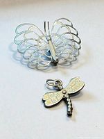Front view of sterling filigree butterfly brooch and opal inlaid dragonfly pendant
