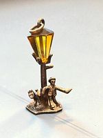 Front angle showing full charm including figure, dog, lamp post and yellow gemstone