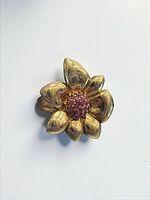 Front view of gold-gilt flower ring showing ruby cluster centre and petal form