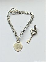 Bracelet and pendant laid flat showing design and metal tone