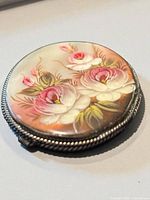 Oblique view showing painted flowers and silver rope border