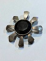 Front view showing sunburst design and faceted onyx