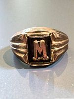 Front view showing raised "M" on black face