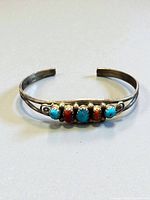 Top view of sterling cuff showing five alternating turquoise and coral cabochons