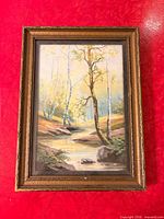 Front view of framed creek landscape painting