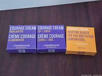 Front view of three boxed Cheekbone Beauty Courage Cream products: Highlighter, Lip + Cheek, and additional variant