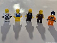 All five LEGO minifigures standing in a row