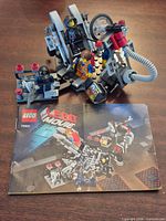 Front view showing assembled Melting Room build, three minifigures and instruction booklet