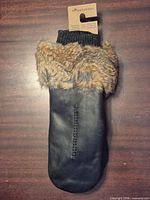 Front view of black leather mitten with fur trim and knit cuff
