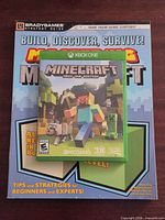 Front view showing Minecraft Xbox One case on top of BradyGames guide