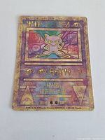 Front of Ancient Mew promo card showing holographic artwork and rune text