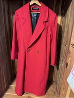 Front view of full-length red wool coat on hanger