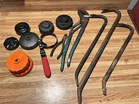 Group shot showing all tools laid out on floor: pry bars, cap wrenches, strap wrench, pliers
