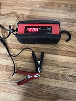 Full view of Battery Tender Xtreme maintainer showing LED display lit, clamps and cords visible