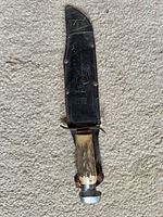 Knife in sheath front view on carpet