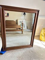 Full view of mirror leaning against wall showing frame and reflection