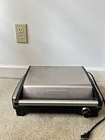 Closed grill front view showing brand name and cord