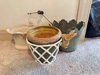 Three planters with bunny ornament and lawn mower stake displayed together